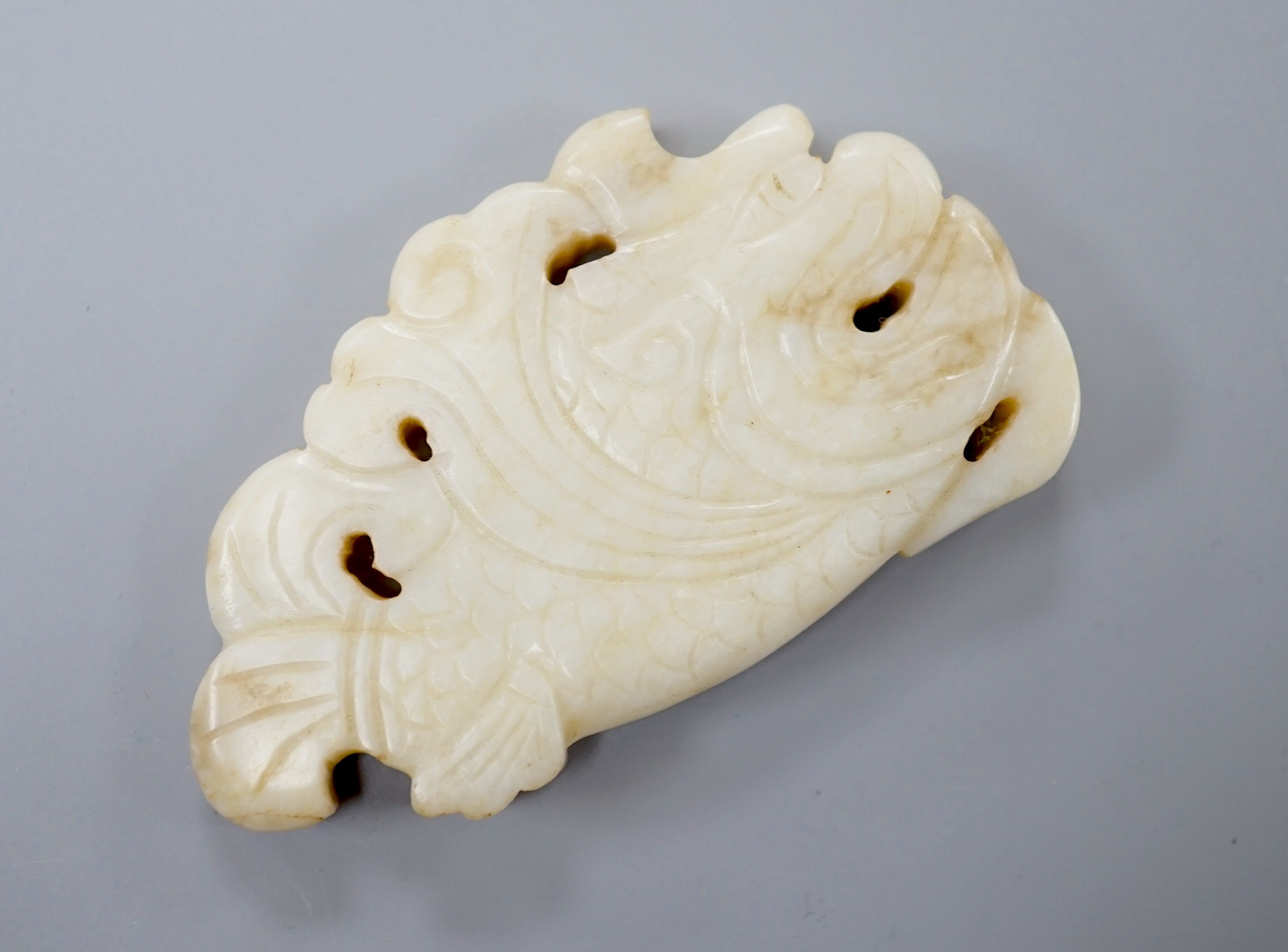 A Chinese white and black jade ‘dragon-fish’ plaque, 19th/20th century, 6cm